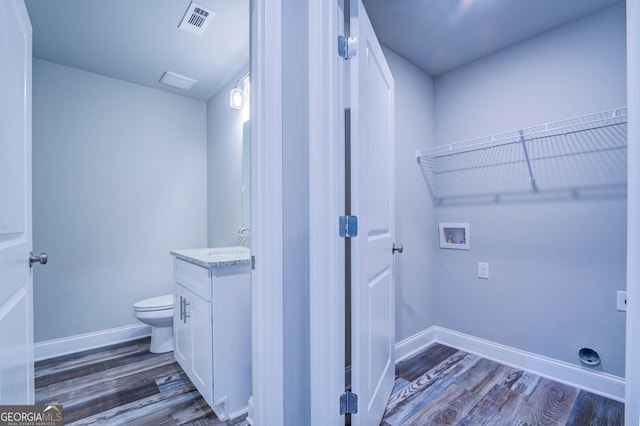 clothes washing area featuring hookup for a washing machine, sink, and dark hardwood / wood-style flooring