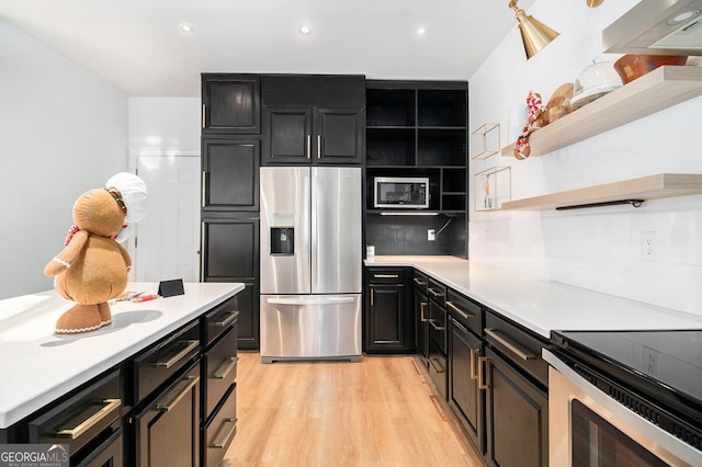 kitchen featuring backsplash, light wood-type flooring, and appliances with stainless steel finishes