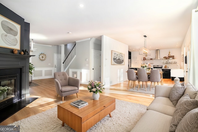 living room featuring crown molding and light hardwood / wood-style floors