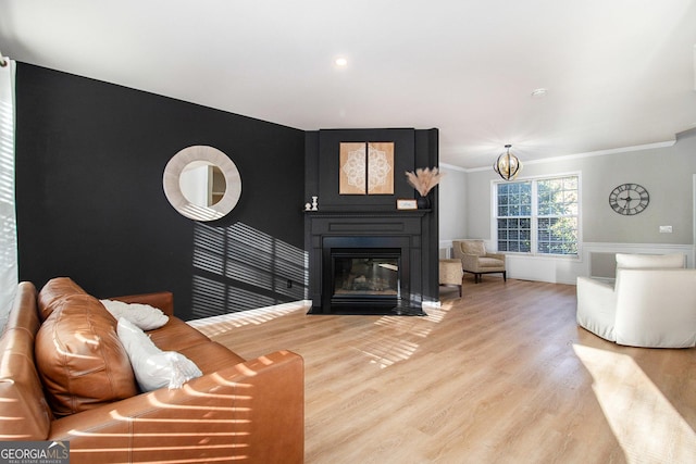 living room with ornamental molding, a large fireplace, and hardwood / wood-style floors