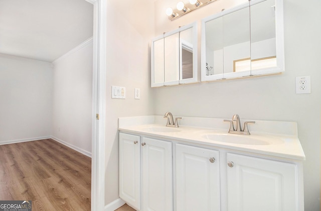 bathroom featuring hardwood / wood-style flooring, ornamental molding, and vanity