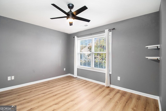 empty room with ceiling fan and light hardwood / wood-style floors