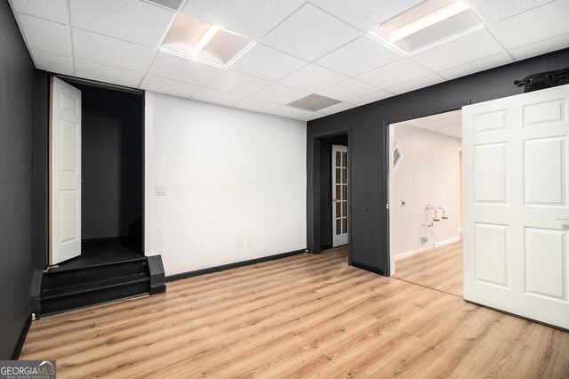 interior space featuring a drop ceiling and light wood-type flooring