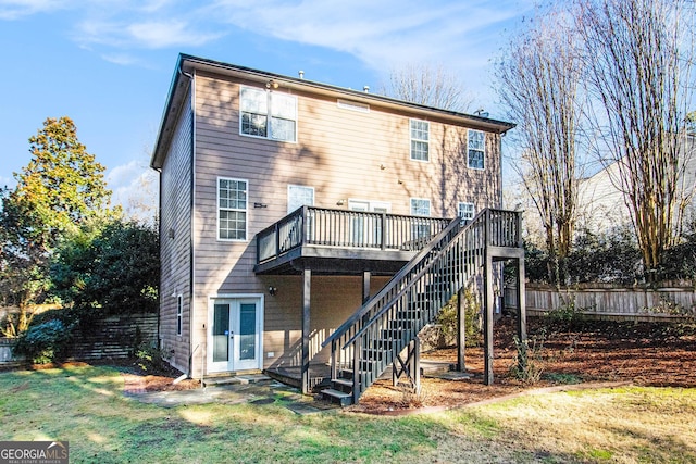 back of property with a yard, french doors, and a deck