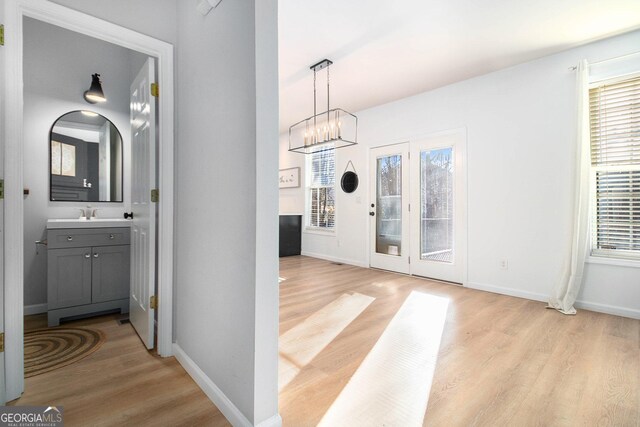 foyer featuring sink, a notable chandelier, and light hardwood / wood-style flooring