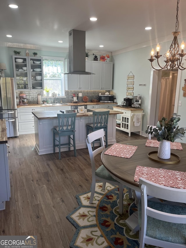 dining space featuring ornamental molding, sink, dark wood-type flooring, and a notable chandelier