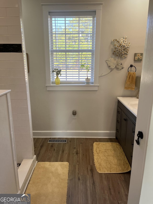 bathroom featuring vanity, wood-type flooring, and walk in shower