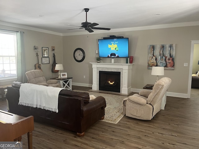 living room with dark hardwood / wood-style flooring, ornamental molding, and ceiling fan