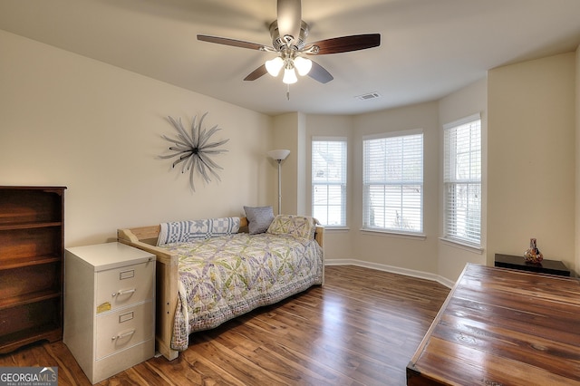 bedroom with dark hardwood / wood-style flooring and ceiling fan