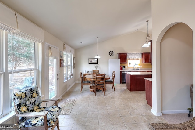 tiled dining space with vaulted ceiling