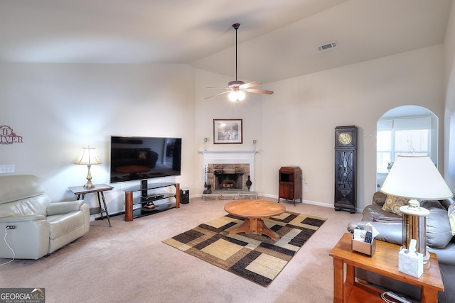 living room with light carpet, a fireplace, high vaulted ceiling, and ceiling fan