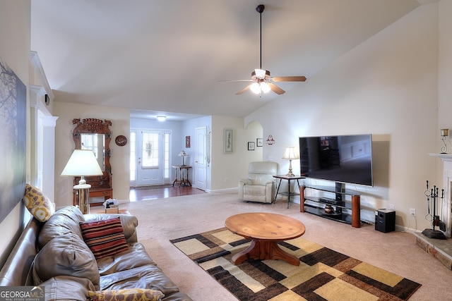 living room with ceiling fan, lofted ceiling, and carpet