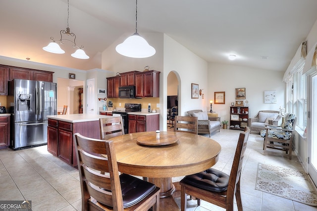 tiled dining area featuring high vaulted ceiling