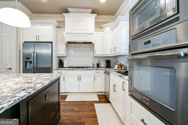 kitchen with stainless steel appliances, ornamental molding, white cabinets, and light stone counters