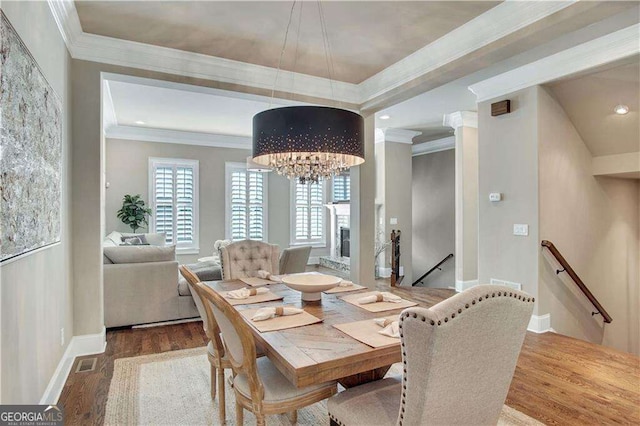 dining space with an inviting chandelier, wood-type flooring, and ornamental molding