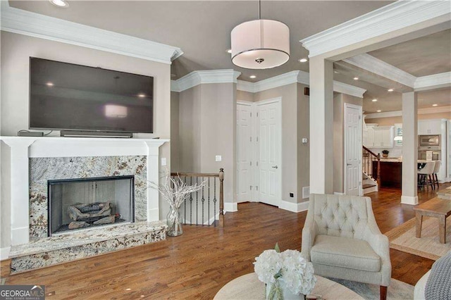 living room with crown molding, a fireplace, and dark hardwood / wood-style flooring