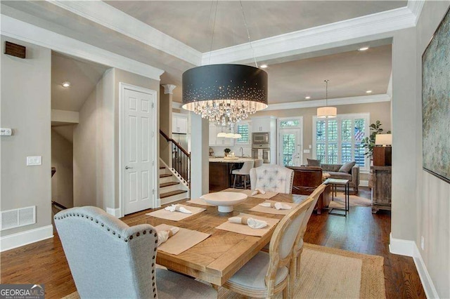 dining space with a notable chandelier, crown molding, and dark wood-type flooring