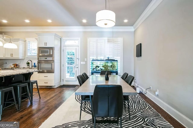 dining space featuring sink, crown molding, and dark hardwood / wood-style floors