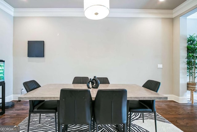 dining space with dark wood-type flooring and ornamental molding