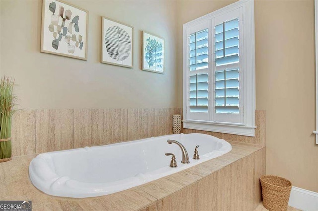 bathroom with a relaxing tiled tub and a wealth of natural light