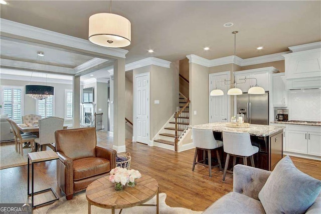 living room featuring ornamental molding and light hardwood / wood-style flooring