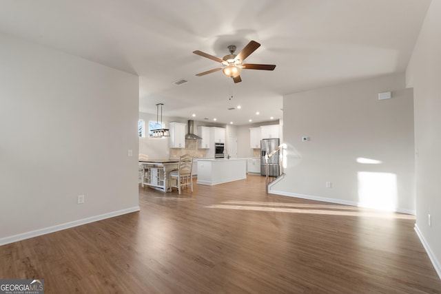 unfurnished living room featuring hardwood / wood-style floors and ceiling fan