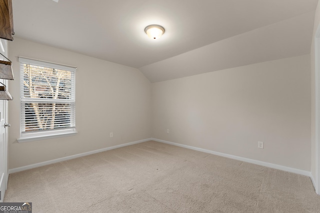 unfurnished room with lofted ceiling and carpet flooring