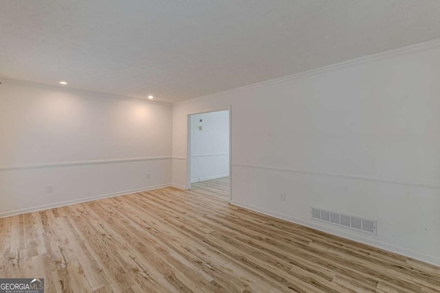 spare room featuring ornamental molding and light hardwood / wood-style flooring