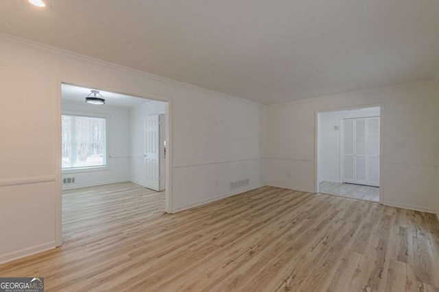 unfurnished room with crown molding and light hardwood / wood-style flooring