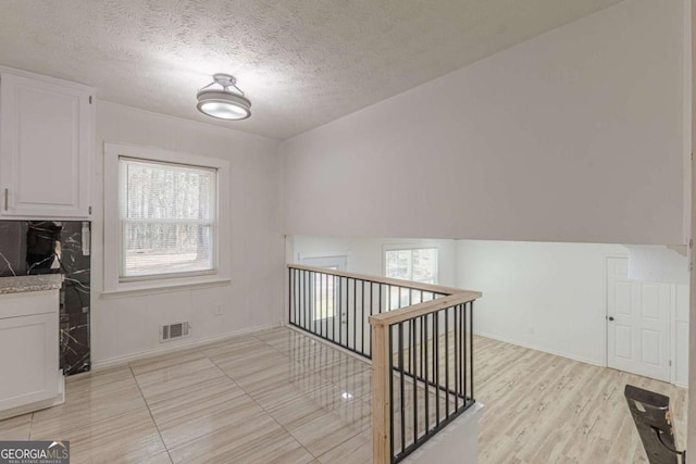 interior space featuring a textured ceiling and light wood-type flooring