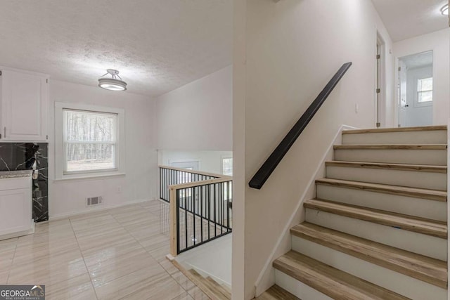 stairway with a textured ceiling