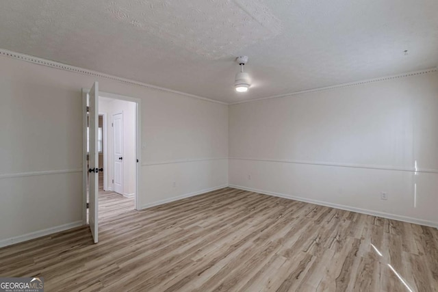 spare room featuring light hardwood / wood-style flooring and a textured ceiling