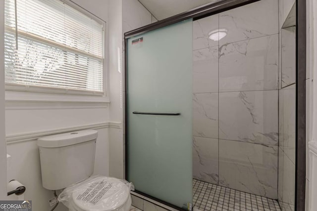 bathroom featuring toilet and an enclosed shower