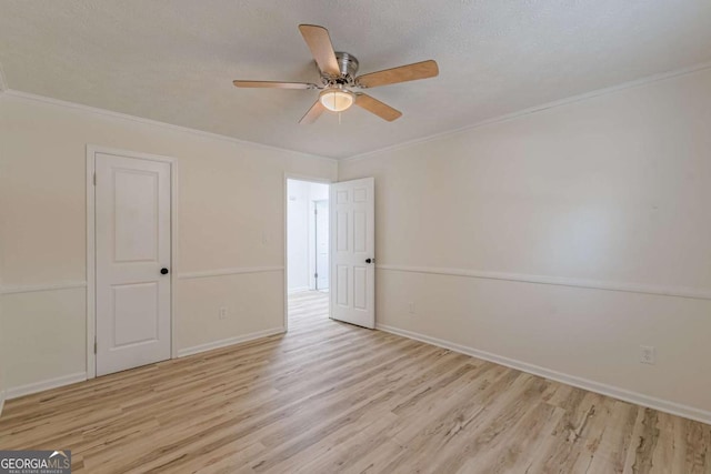 empty room featuring crown molding, light hardwood / wood-style floors, ceiling fan, and a textured ceiling