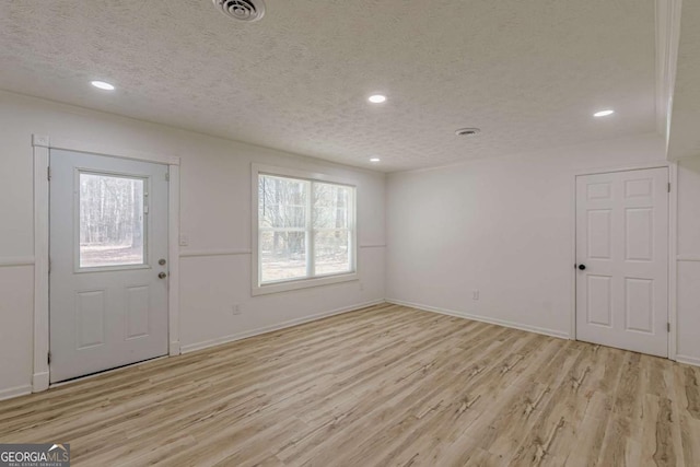 entryway featuring a textured ceiling and light hardwood / wood-style flooring