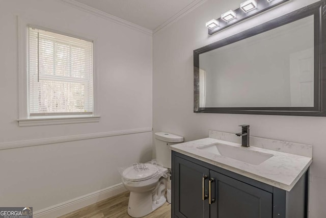 bathroom featuring hardwood / wood-style flooring, ornamental molding, toilet, and vanity