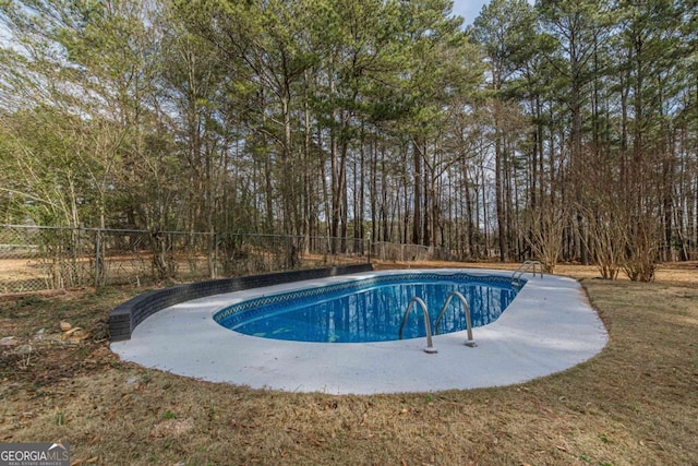 view of swimming pool featuring a yard