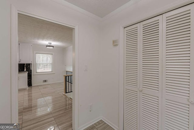 corridor with a textured ceiling and light tile patterned floors