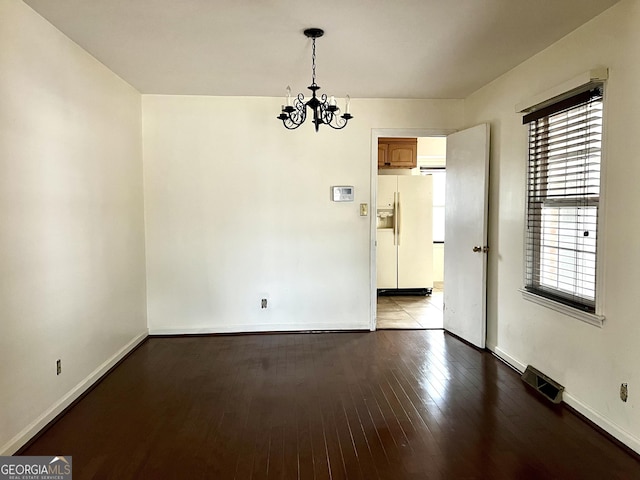 unfurnished room with a chandelier and light hardwood / wood-style floors