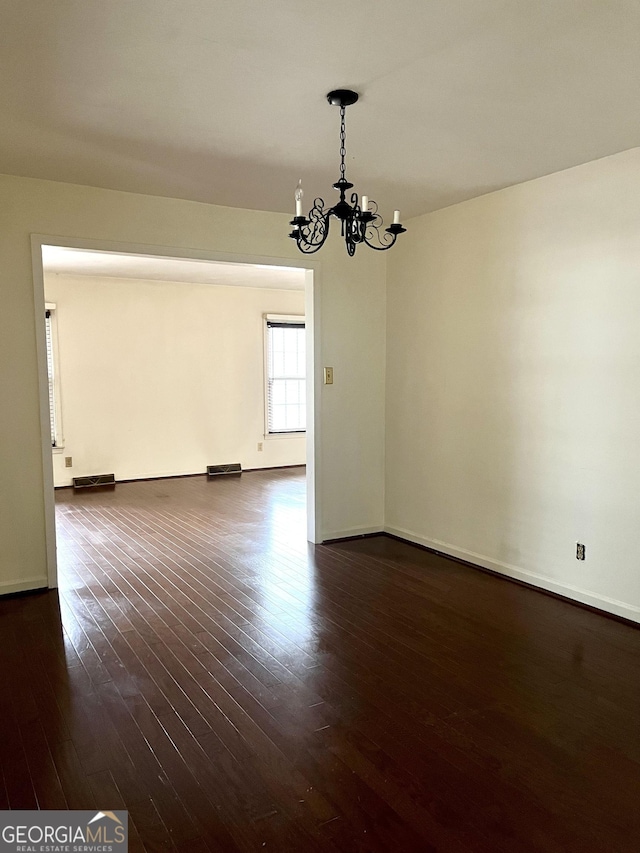 interior space featuring dark wood-type flooring and an inviting chandelier