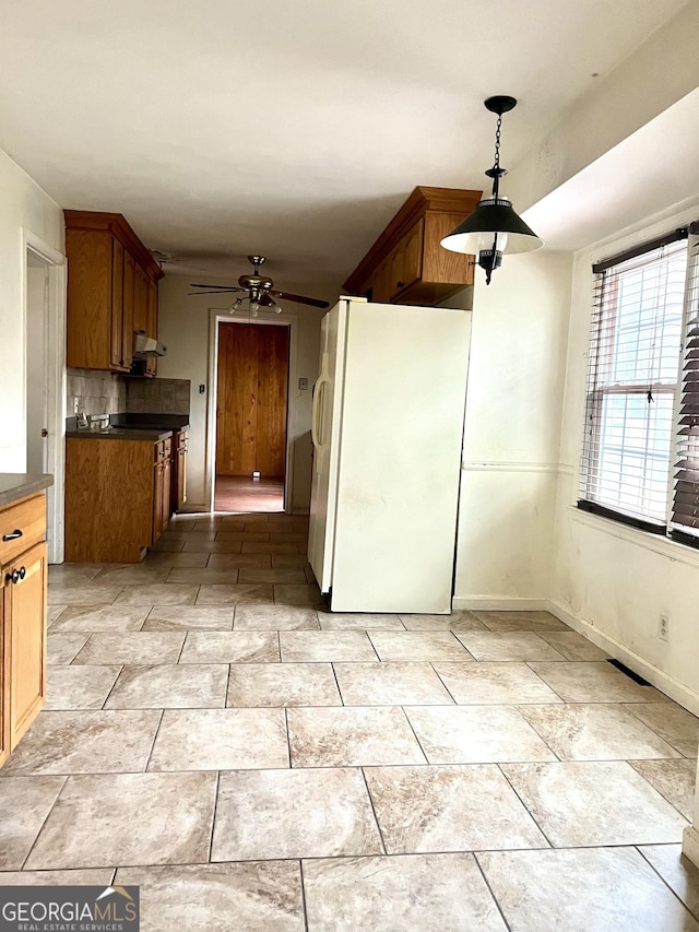 kitchen with tasteful backsplash, hanging light fixtures, ceiling fan, and white fridge