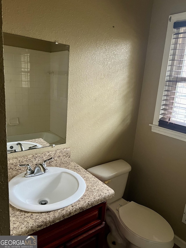 bathroom with vanity, a wealth of natural light, and toilet