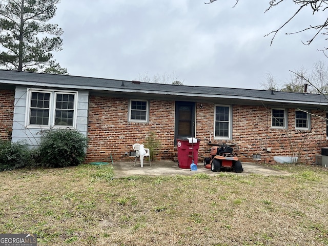 rear view of property with a yard and a patio area