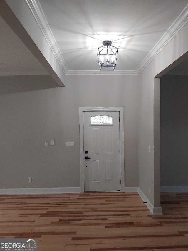 foyer featuring a notable chandelier, crown molding, and wood-type flooring