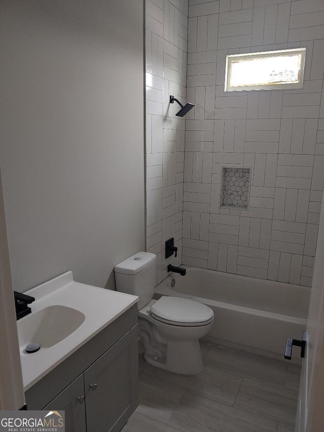 full bathroom with tiled shower / bath combo, vanity, and toilet