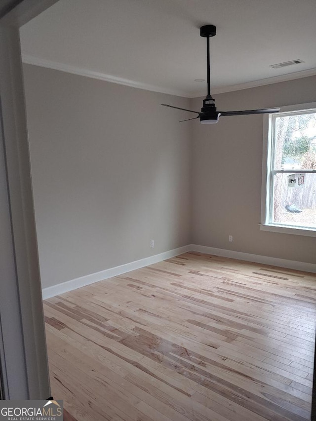 empty room featuring light hardwood / wood-style flooring and ornamental molding