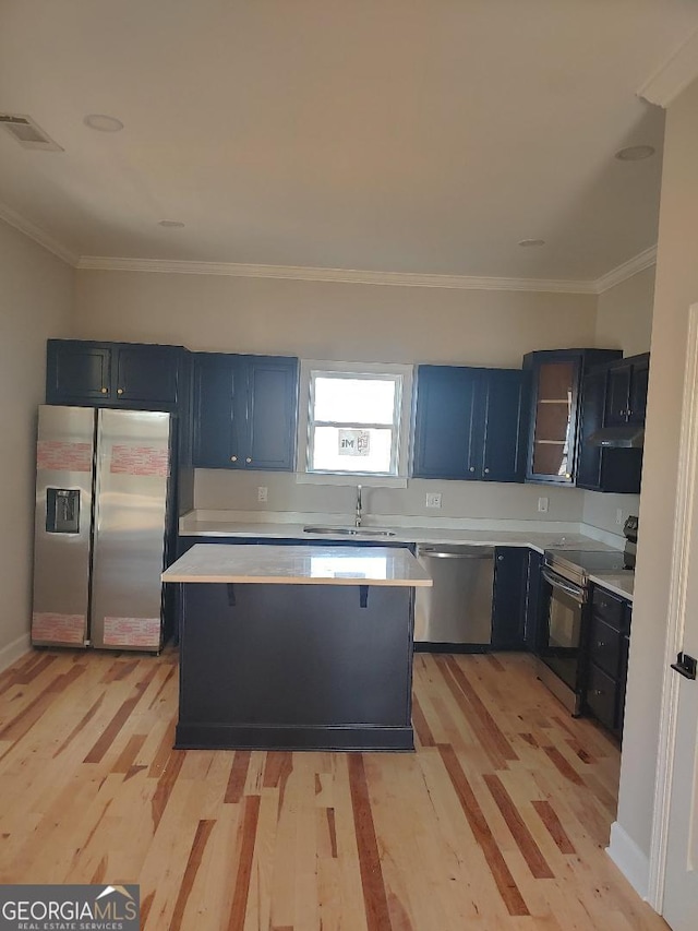 kitchen with crown molding, stainless steel appliances, light hardwood / wood-style floors, and sink