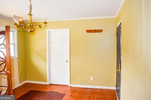 empty room with ornamental molding and a chandelier