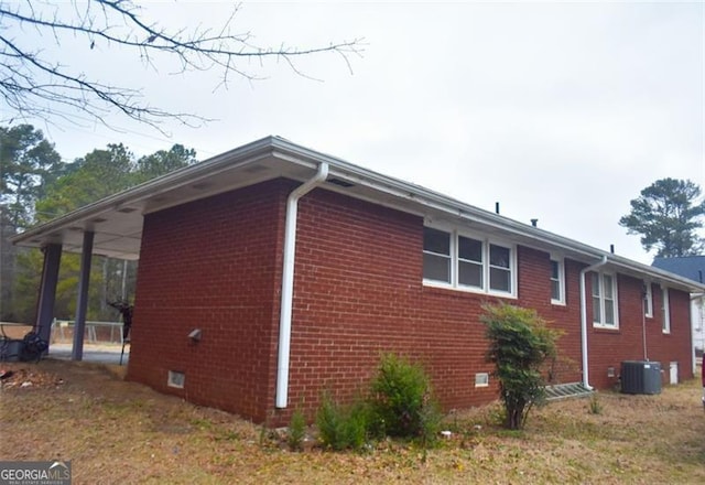 view of side of home with a yard and central air condition unit