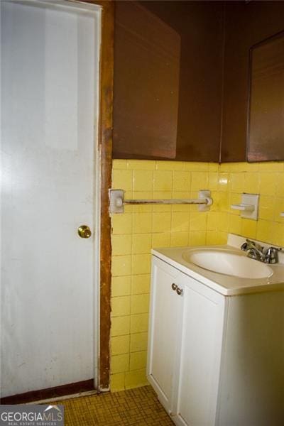 bathroom with vanity and tile walls